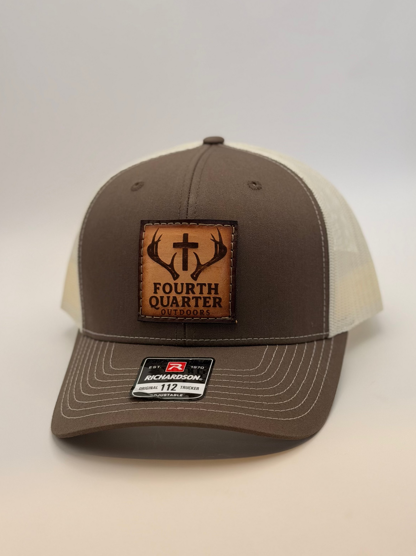 Brown and beige cap with a leather patch on a white background